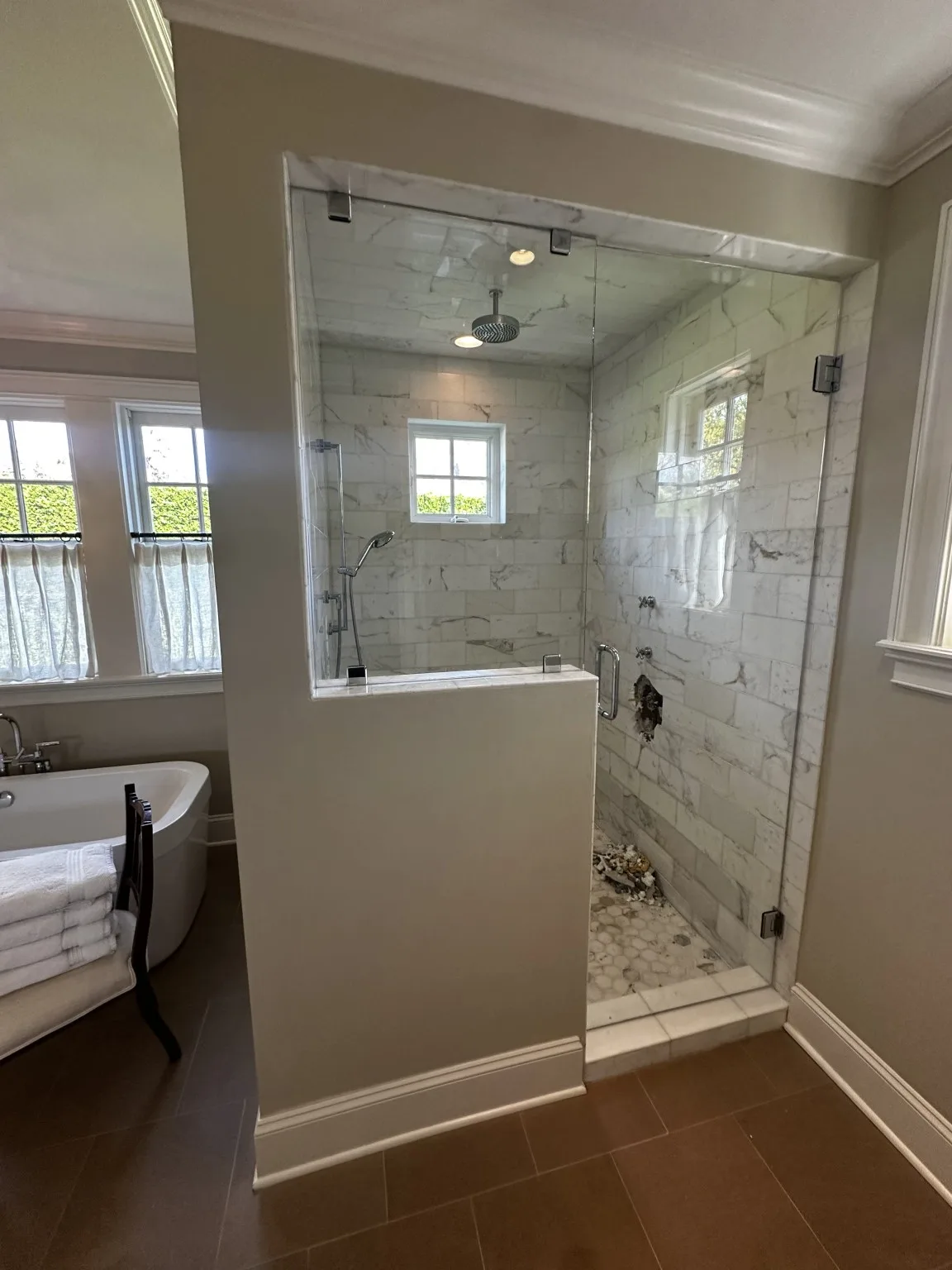 Custom marble-look shower with glass enclosure