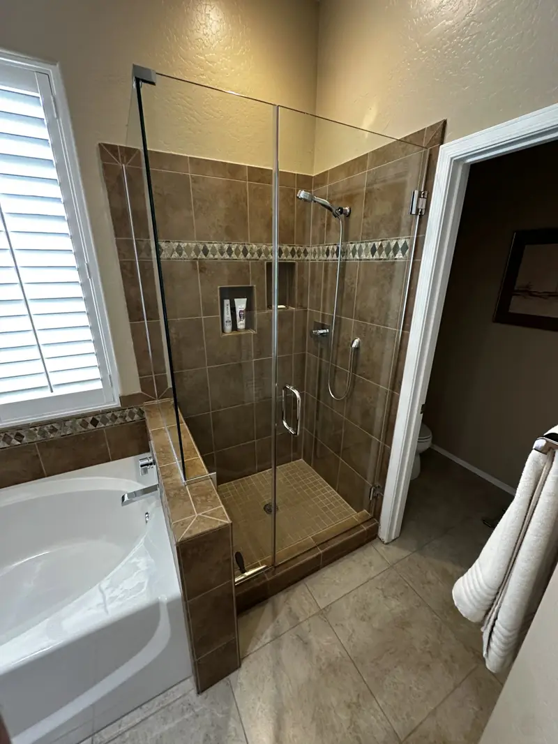 Custom tiled shower with accent border and glass enclosure