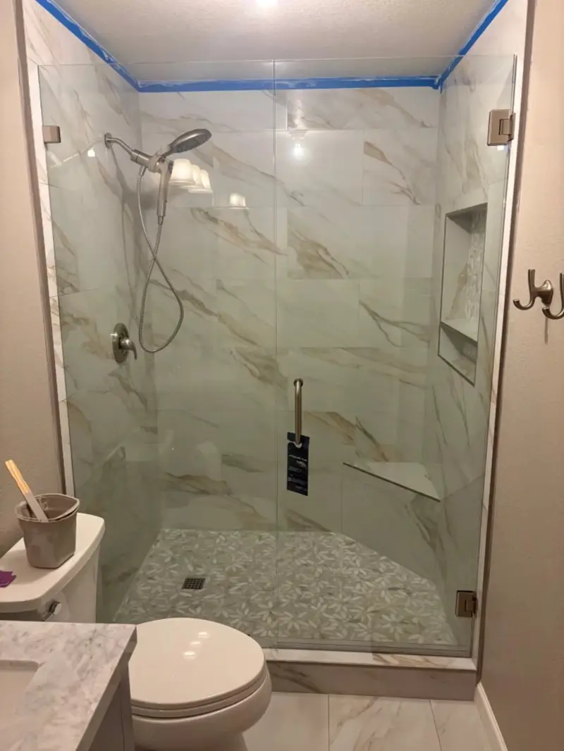Marble-look glass shower with mosaic floor