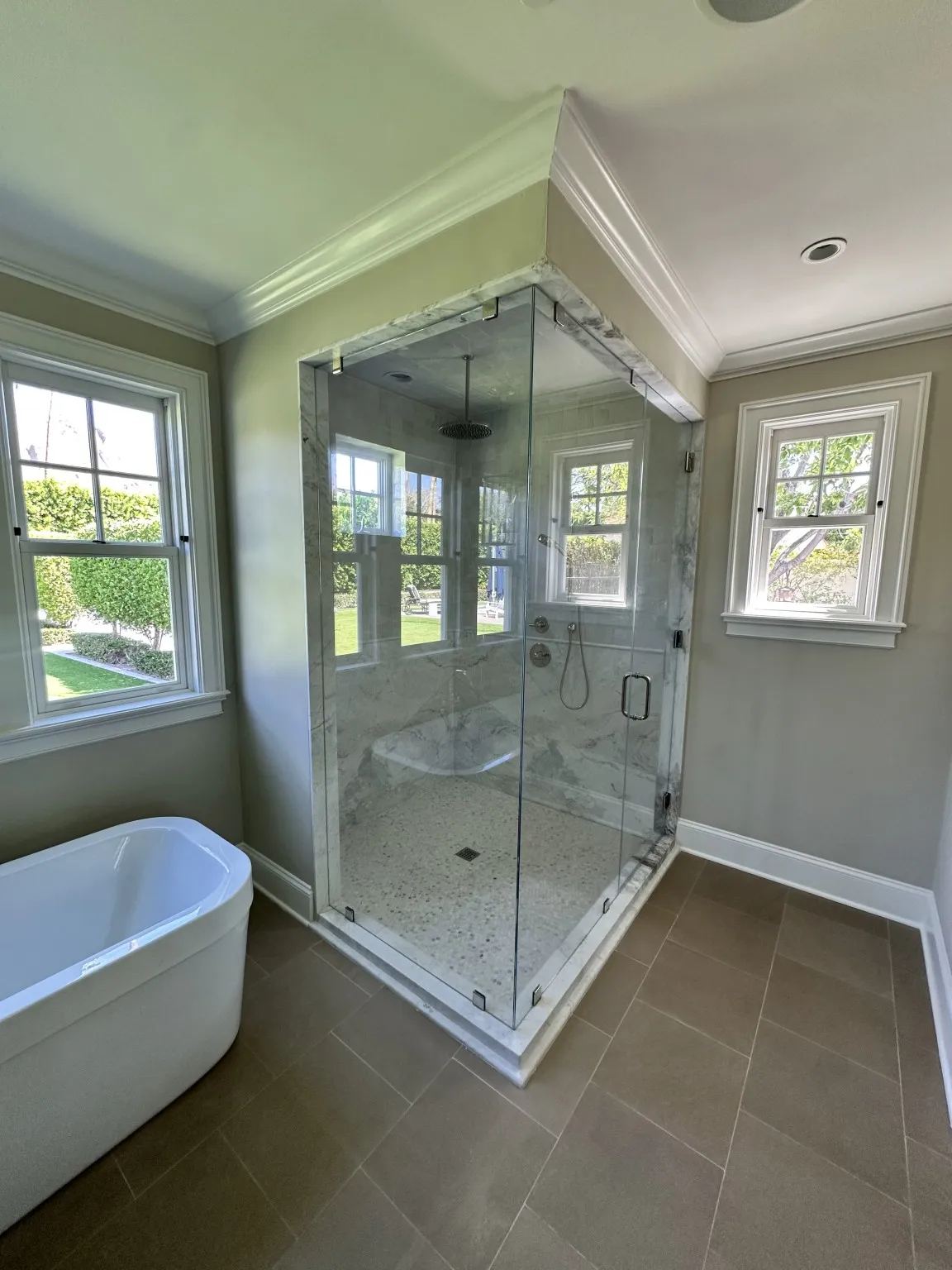 Luxury glass shower with marble tile and large-format bathroom flooring
